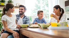 family with young children eating breakfast